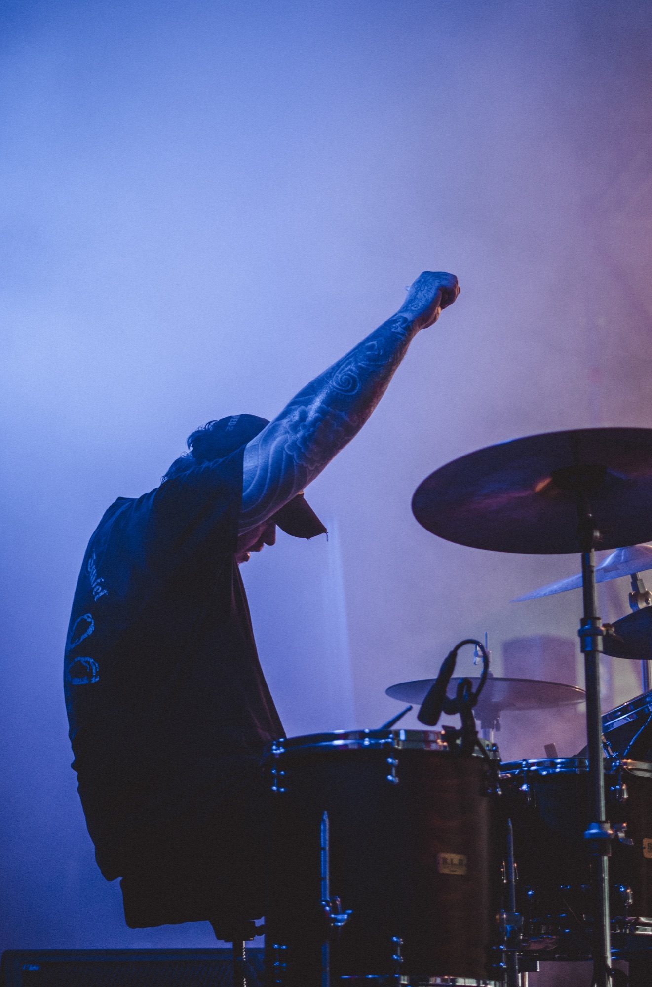 Drummer performing under blue stage lights